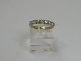 a yellow gold ring with three diamonds on a clear surface