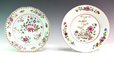 two plates with floral designs are sitting side by side on a white surface