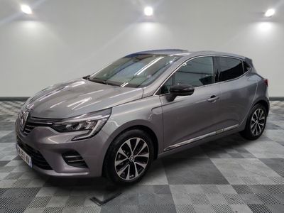 Une voiture grise est garée dans une pièce au sol carrelé en damier.
