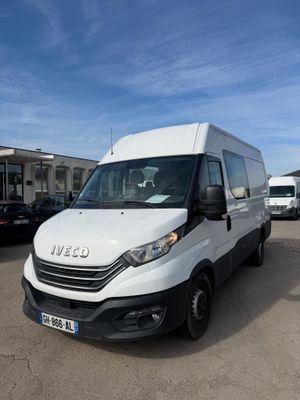 la camionnette blanche est garée dans un parking avec d'autres véhicules