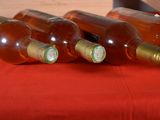 several bottles of wine are lined up on a red cloth