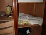 a bunk bed in the corner of a closet next to a lamp
