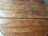 an image of a round wooden table on a parquet floor