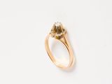 a close up of a gold ring with a diamond on it