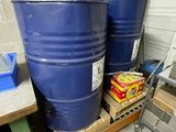 two blue barrels sitting on a pallet in a garage