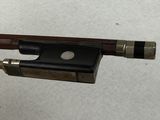 a close up of a violin bow on a white surface