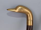 a close up of a gold colored duck head on a cane