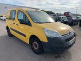 La camionnette jaune est garée sur un parking, à côté d'autres voitures.