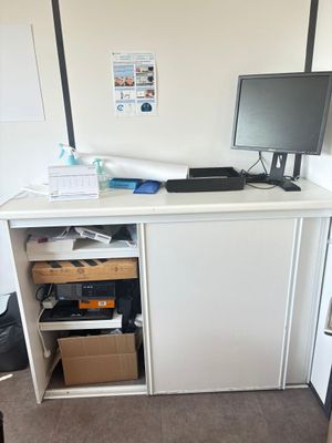 un bureau équipé d'un écran d'ordinateur et d'une imprimante
