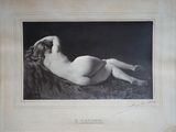 une vieille photo d'une femme nue allongée sur un lit