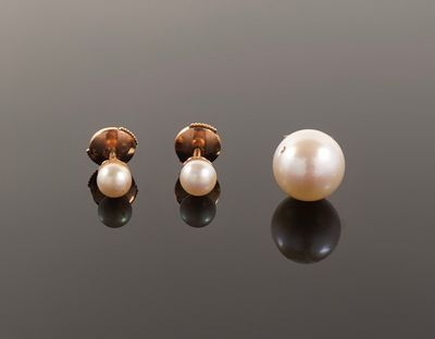 a pair of pearl and gold earrings on a black surface