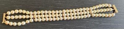 bracelet en perles avec un fermoir doré sur un fond noir