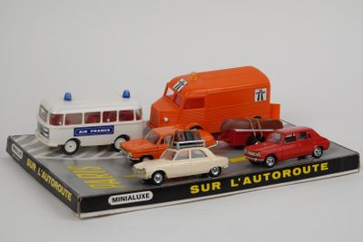 trois petites voitures et un bus exposés sur une table