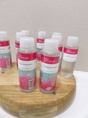 six flacons de gel hydroalcoolique posés sur un support en bois
