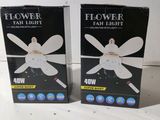 two boxes of flower fan light sitting next to each other on a table