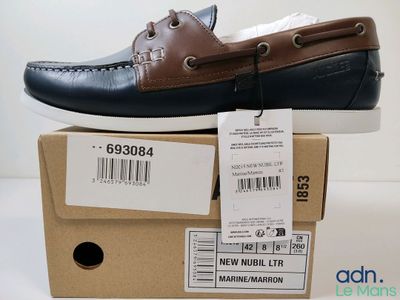 des chaussures bateau pour homme dans une boîte posée sur un carton