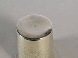 a silver thimble that is sitting on a table