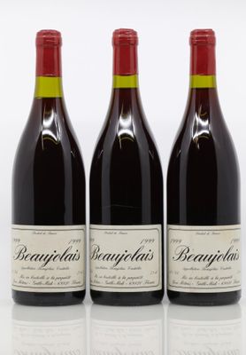 trois bouteilles de vin rouge sont alignées sur une surface blanche