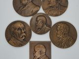 five bronze medallions of men with faces of different ages