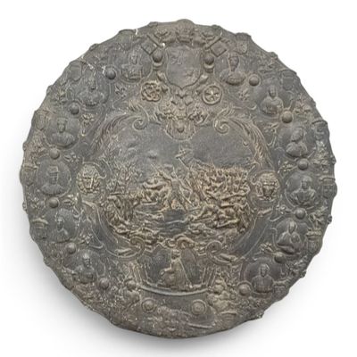 an old silver coin with a design on it on a white surface