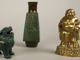 three statues of buddhas and a statue of a dog