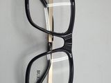 pair of black and gold eyeglasses hanging on a white wall