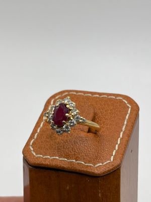 une photo d'une bague sertie d'un diamant et d'un rubis, dans un écrin