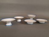 a set of five white and blue dishes with blue rims