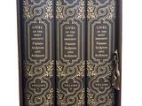 three books in a wooden box with gold designs on them