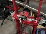 a red machine that is sitting in a garage