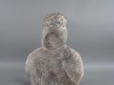 an image of a stone statue of a bird on a gray background