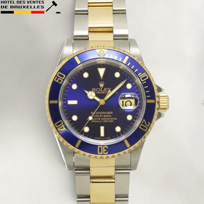 a watch with a blue dial on a gold bracelet
