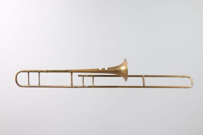 a brass trombone with a white background