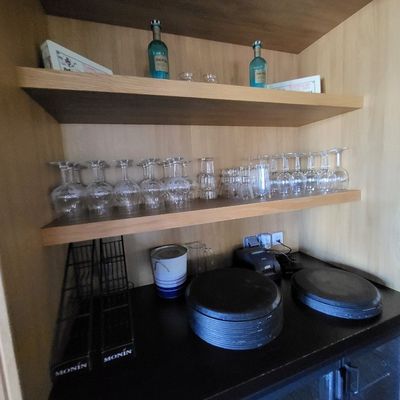 de nombreux verres et assiettes sur une étagère dans la cuisine