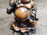a small statue of a laughing buddha holding a ball