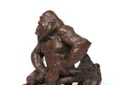 an image of a bronze statue of a gorilla sitting on a rock