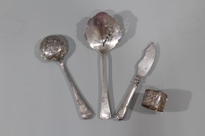 trois cuillères en argent et un couteau posés sur un plan de travail blanc