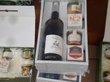 bottles of wine and boxes of food sit on a tiled floor