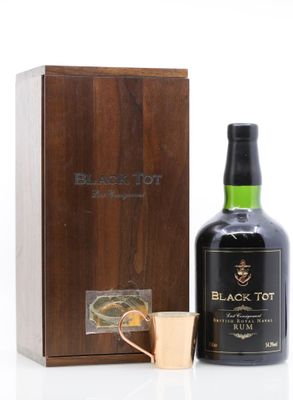 a bottle of black tot next to a copper mug
