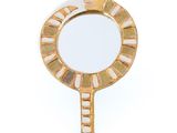 miroir avec un cadre doré et un motif blanc et doré