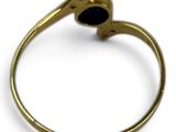 a close up of a gold ring with a black stone