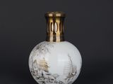 an image of a white vase with a gold lid on a black background