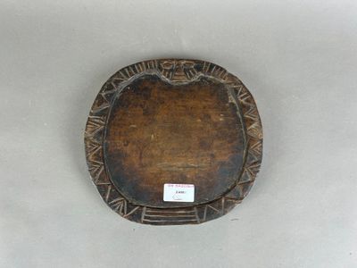 une photo d'une assiette en bois posée sur une surface blanche