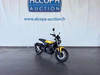 a yellow motorcycle parked in front of a white wall
