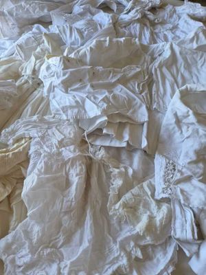 a bed that has a lot of white sheets on it