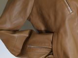 the jacket is brown and has a zipper on the back
