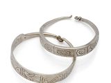 a pair of silver hoop earrings on a white background