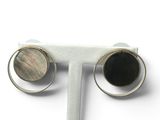 paire de boucles d'oreilles en argent et nacre, posées sur un présentoir blanc