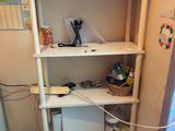 a white shelf with many items on it in a room