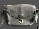 silver leather purse with a metal clasp on a gray background
